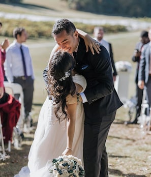 Una parella s'abraça durant una cerimònia de casament a l'aire lliure.