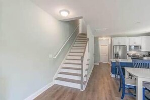 A modern kitchen with white cabinets, a stainless steel refrigerator, and a blue dining area. - Sleeps 36, 12 BR 12 BA, 2 Pools, New Build, 118AB (Surfside Beach)