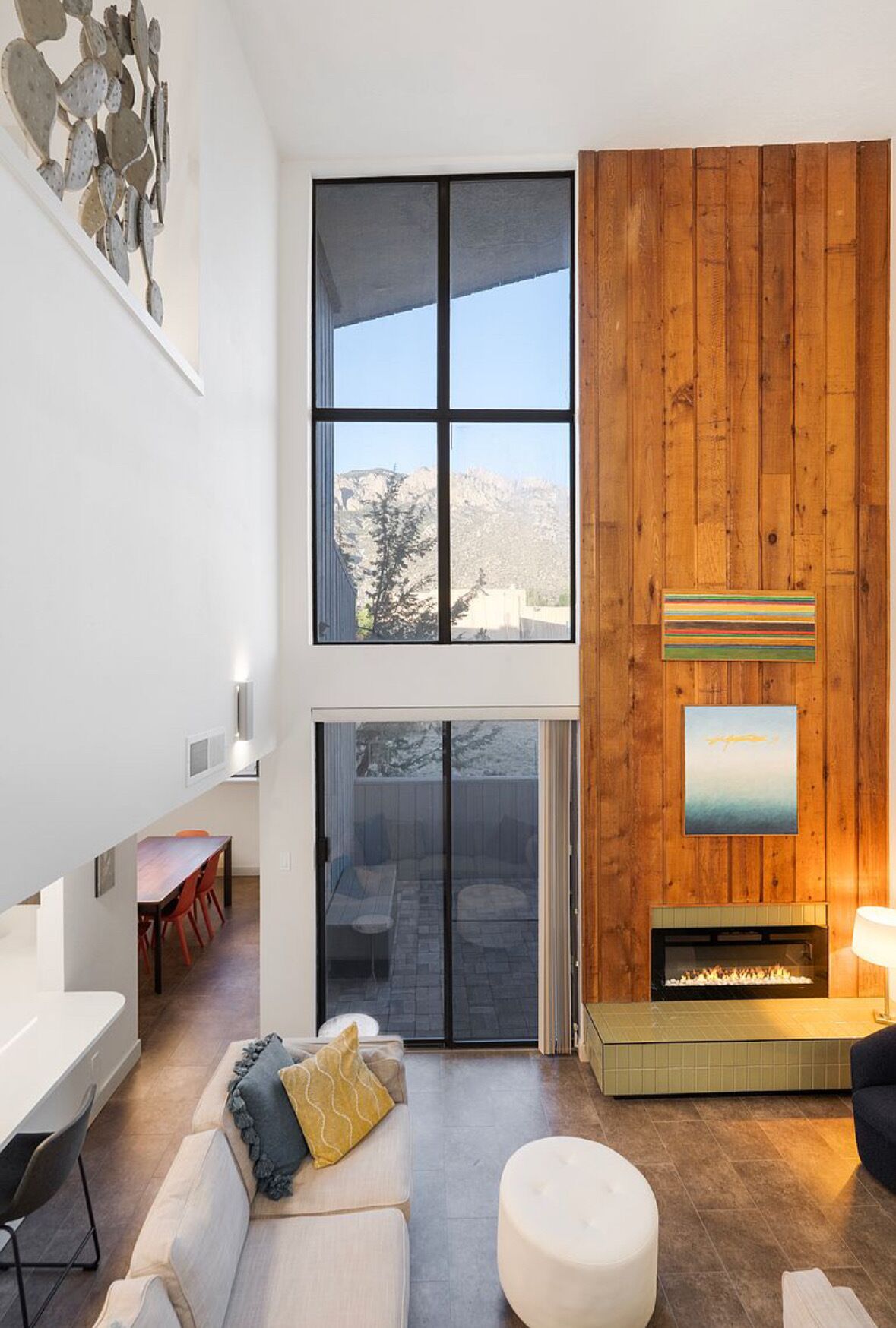Un interior moderno con chimenea, comedor y vistas al exterior.