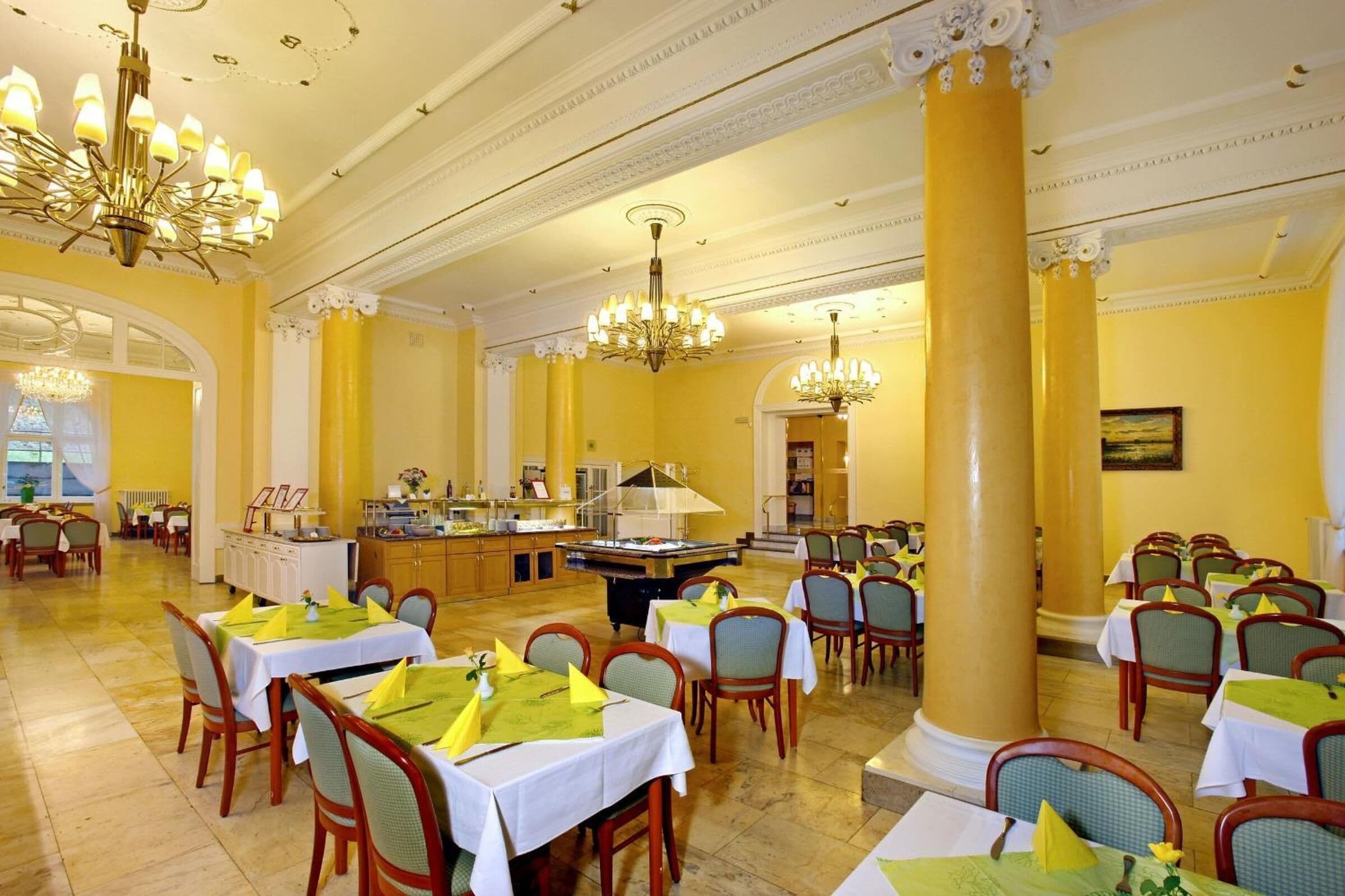 A spacious dining area with multiple tables, chairs, and a central buffet.