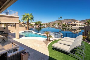 A residential area with a swimming pool, lounge chairs, and a view of a mountain range. - Lakefront Retreat | Free Heated Pool + Game Room (Glendale)
