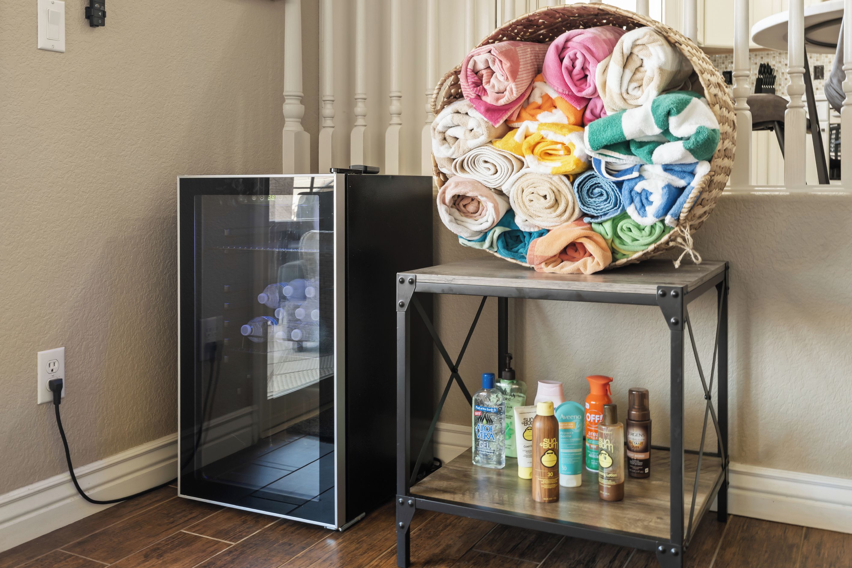 A laundry area with a washing machine, a basket of folded towels, and a shelf with toiletries.