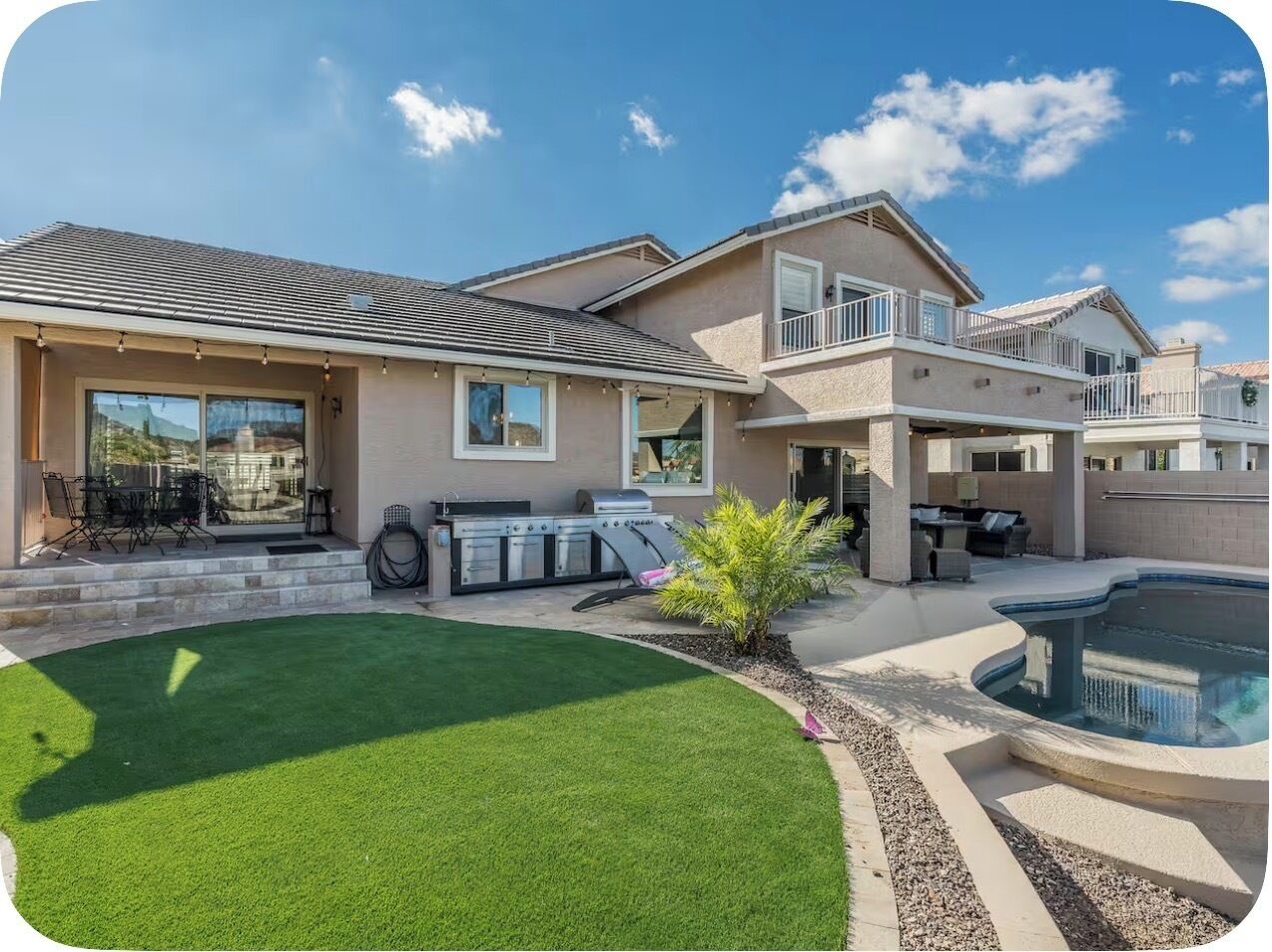 A residential property with a swimming pool, a barbecue area, and a well-maintained lawn.
