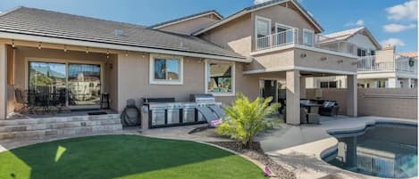 A residential property with a swimming pool, a barbecue area, and a well-maintained lawn.