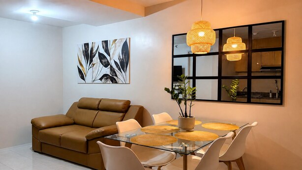 Ein modernes Wohnzimmer mit Glastisch, Ledersofa und zeitgemäßen Pendelleuchten.