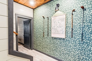 A hallway with patterned wallpaper, a framed map, and several wall-mounted lights. - 8BR/Golf Simulator/FREE Waterpark/PrivatePool (Sevierville)