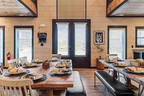 A dining area with wooden tables and benches, arranged for a meal. - 8BR/Golf Simulator/FREE Waterpark/PrivatePool (Sevierville)