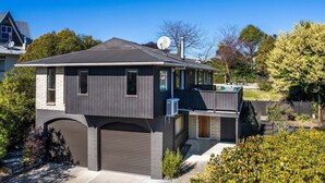 Ein zweistöckiges Haus mit Garage, Satellitenschüssel und einem gepflegten Garten.
