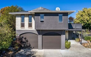 A two-story house with a garage, a satellite dish, and a covered porch.