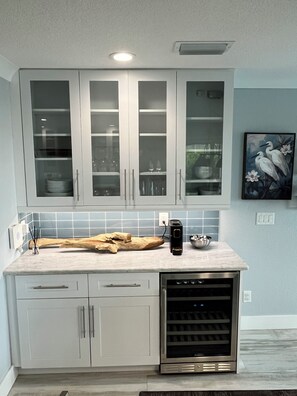 A kitchen with white cabinets, a built-in oven, and a tiled backsplash. - Beautiful Home (Cape Coral)