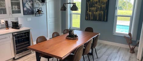Une cuisine moderne avec une table à manger en bois, des chaises et un four encastré.