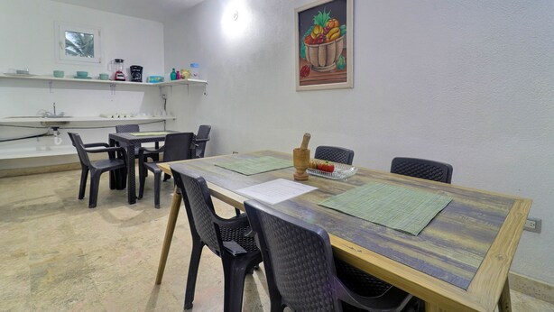 A dining area with a wooden table, black chairs, and a painting on the wall.