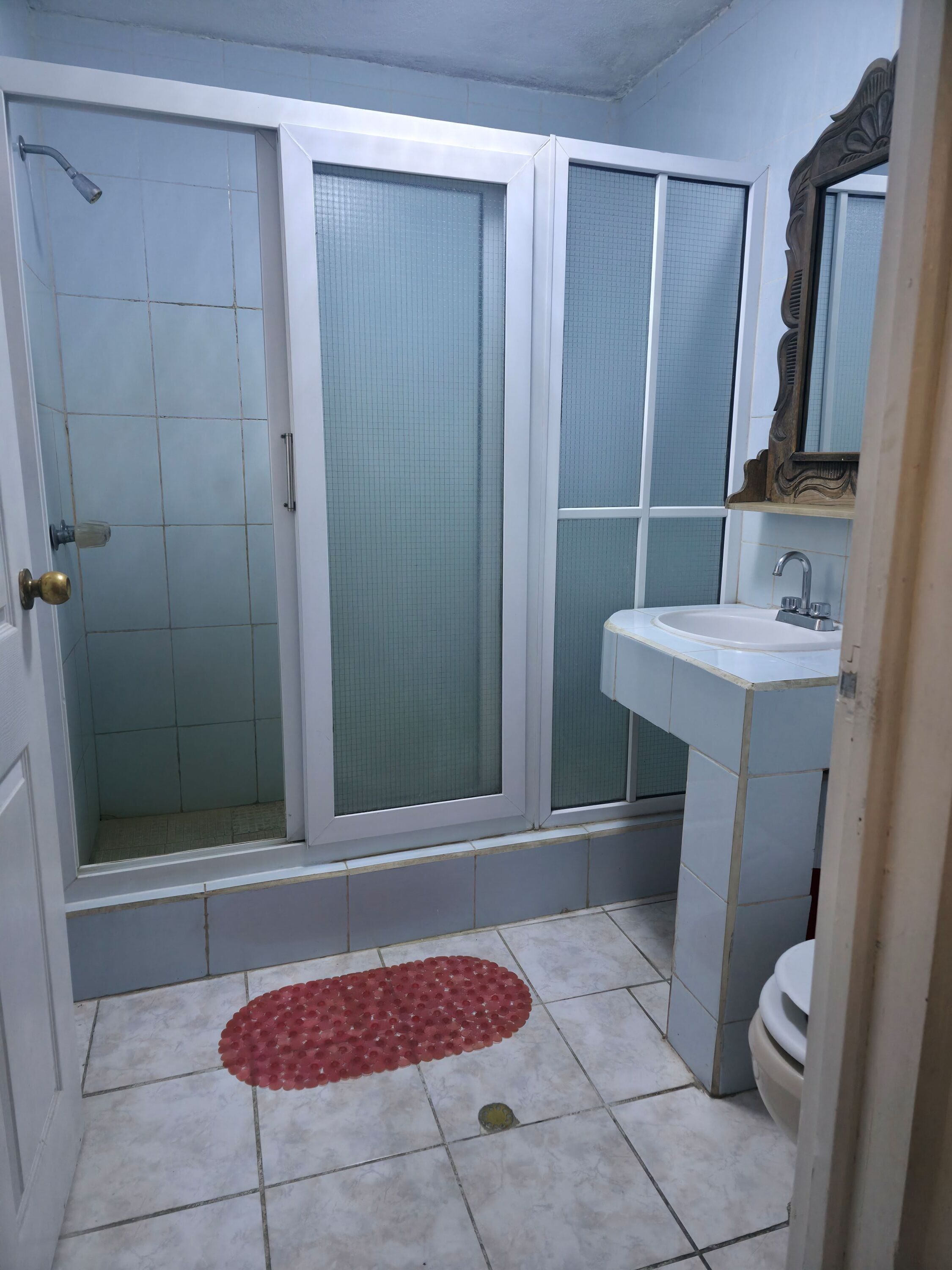 Une salle de bain avec une douche, un lavabo et des toilettes.