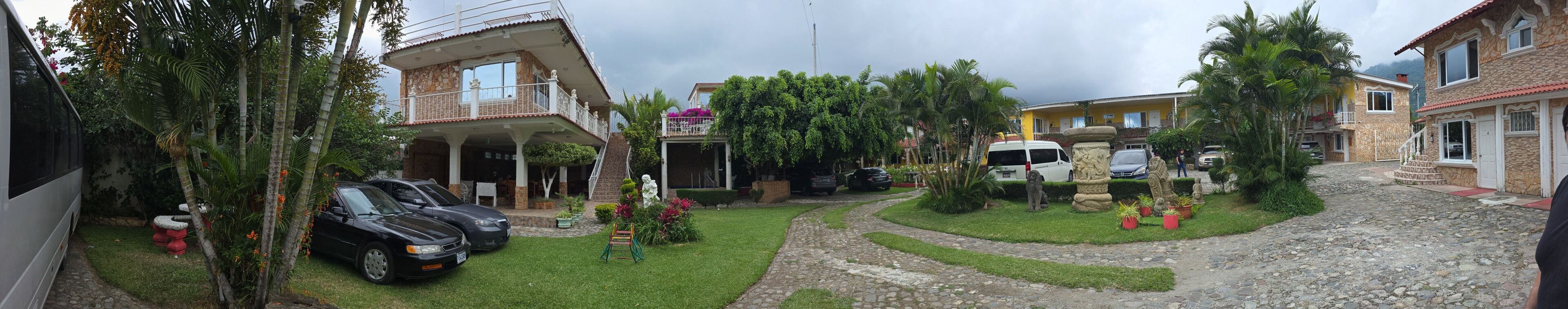 Un quartier résidentiel composé de plusieurs maisons, avec une allée pavée et des voitures garées.