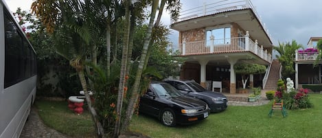 Un barrio residencial con varias casas, un camino de entrada pavimentado y coches aparcados.