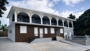 A modern building with a flat roof, multiple balconies, and a parking area. - Solar Island Base | WiFi, Parking and Near Ferry (Ceiba)