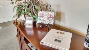 En receptionsdisk med en välkomstbroschyr, ett inramat förslagskort och en krukväxt.