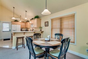 A dining area with a round table, four chairs, and pendant lighting.
