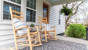 A porch with two rocking chairs, a patterned rug, and a hanging plant. - Cozy, Clean, 2-bedroom 1 bathroom home in Lexington, TN (Lexington)