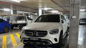 Ett parkeringsgarage med en vit SUV parkerad i en besöksplats.