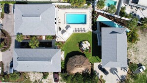 An aerial view of a residential area with multiple houses, a swimming pool, and a small garden area. - The Eden (Fort Myers Beach)