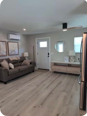 Ein Wohnzimmer mit einer Couch, einem Couchtisch und einem Essbereich mit Tisch und Stühlen.