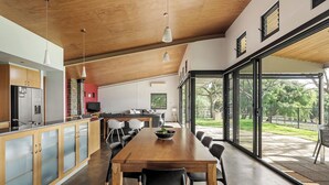 Una cucina moderna con zona pranzo, ampie finestre e vista sull'esterno.