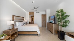 Ein modernes Schlafzimmer mit einem Bett, Nachttischen, einem Fernseher, einer Pflanze und einem Kleiderschrank.