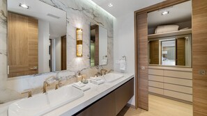Een moderne badkamer met twee wastafels, een grote spiegel en een houten wastafelmeubel.