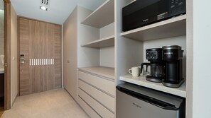 Eine moderne Küche mit integriertem Mikrowellenherd, Kaffeemaschine und Kühlschrank.