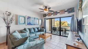A living room with a sofa, coffee table, and artwork on the wall. - Oceanfront 2BR Condo at Princesa Resort with Stunning Sea of Cortez Views (Puerto Peñasco)