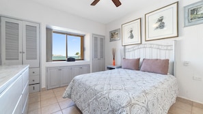 A bedroom with a bed, a window with a view, a dresser, and a nightstand. - Oceanfront 2BR Condo at Princesa Resort with Stunning Sea of Cortez Views (Puerto Peñasco)