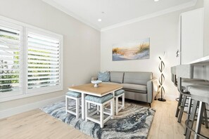 Ein modernes Wohnzimmer mit Sofa, Esstisch und Barbereich.