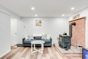 A modern living room with a sofa, a small table, a fireplace, and a motivational poster on the wall. - The Eagles Nest Chalet (Coolbaugh Township)