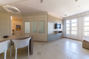 A modern kitchen with a dining area, a TV, and a large window. - Luxury Penthouse W/sea View Jurere Resort Ilc1506 (Florianópolis)