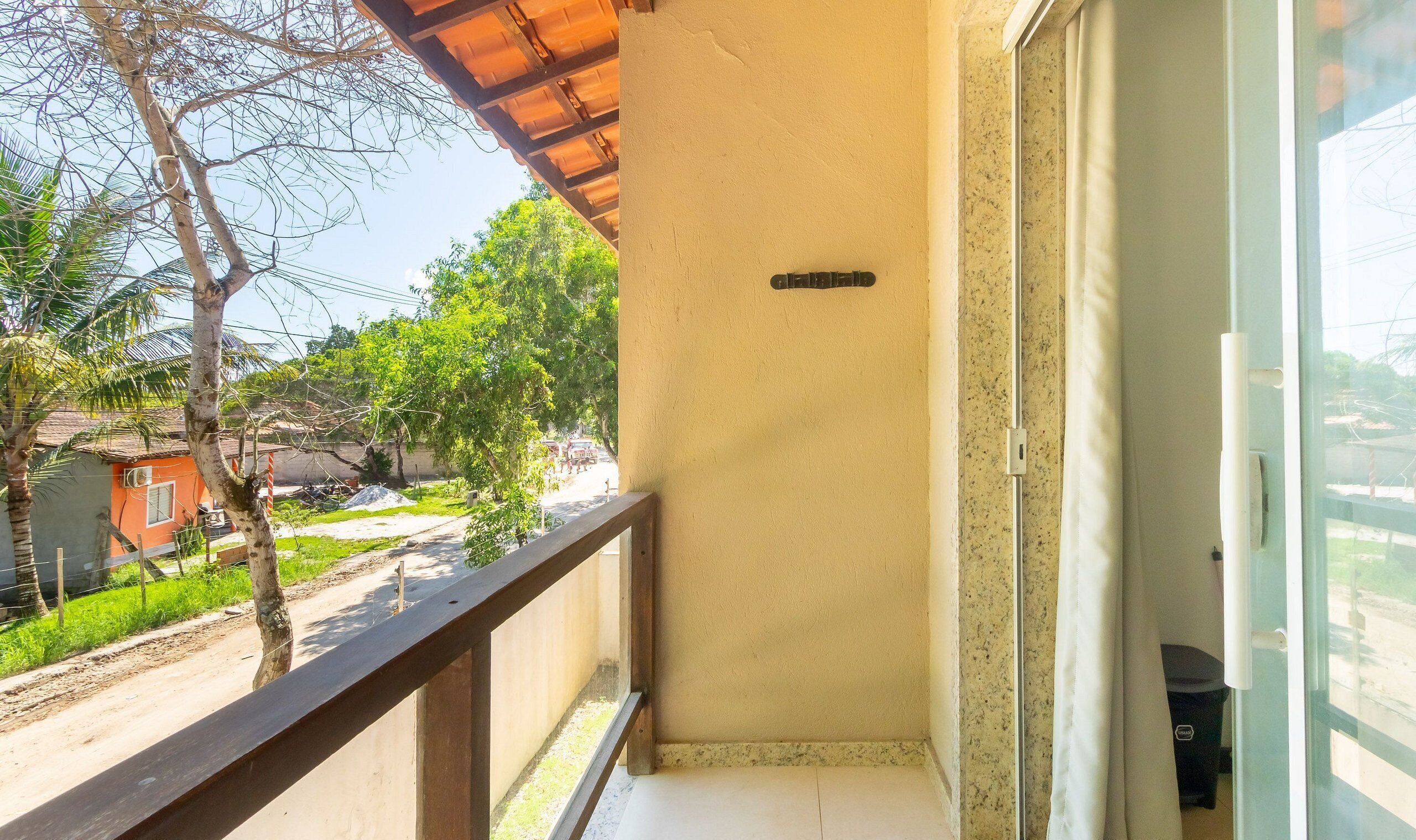 Ein Balkon mit Blick auf ein Wohngebiet, einschließlich eines Hauses und Bäumen.