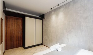 A modern bathroom with a large mirror, a wooden door, and a towel on the floor. - Comfortable Ap 80m Praia dos Ingleses Amc0202 (Florianópolis)