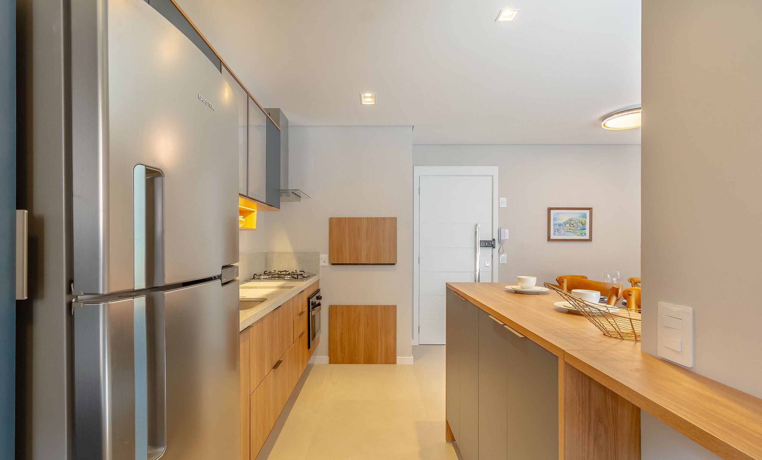 Una cocina moderna con electrodomésticos de acero inoxidable, armarios de madera y una isla central.