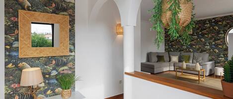 Una sala de estar con un sofá, una mesa de centro y una pared decorada con un mural de peces.