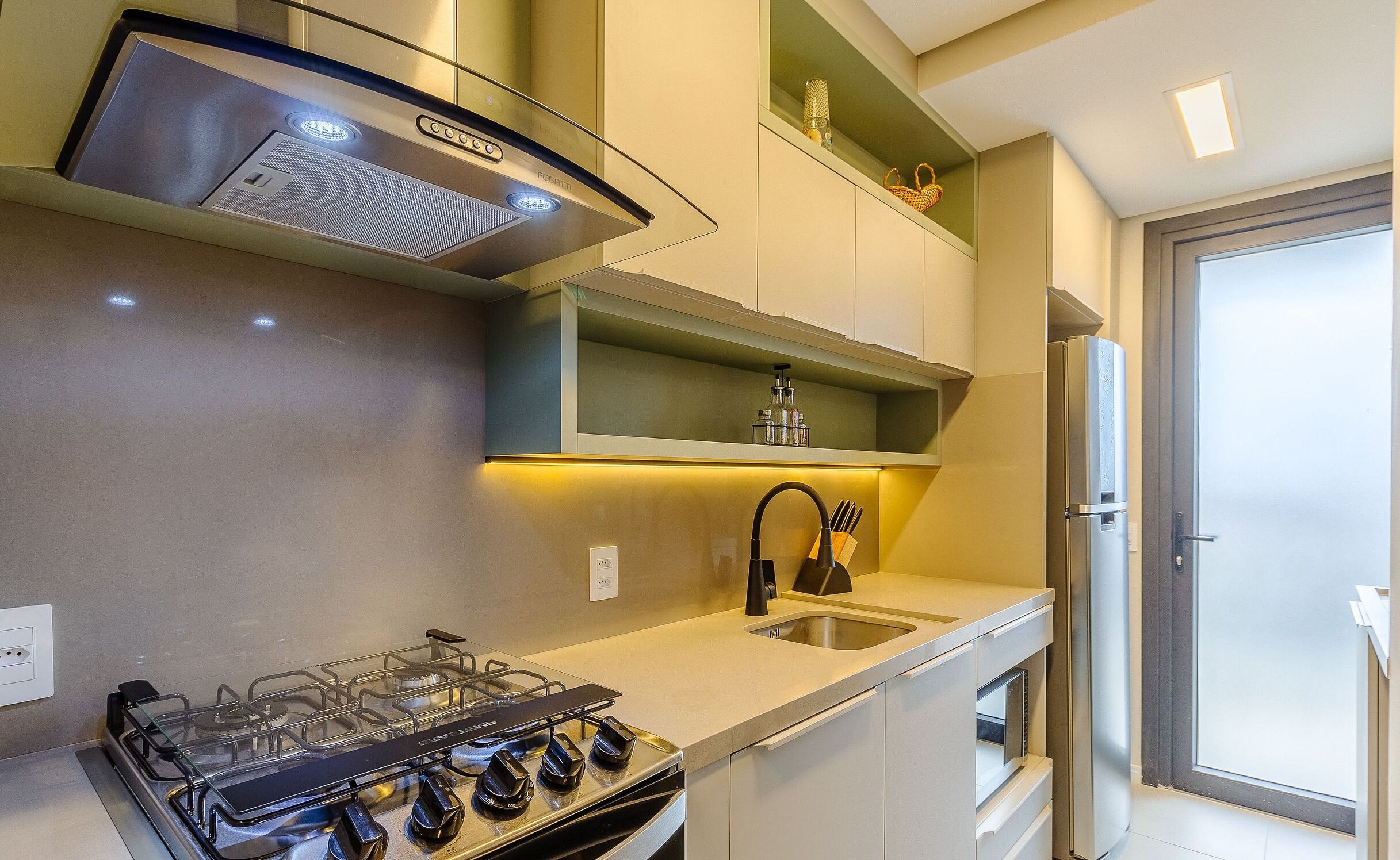 Una cocina moderna con estufa a gas, electrodomésticos de acero inoxidable y horno integrado.