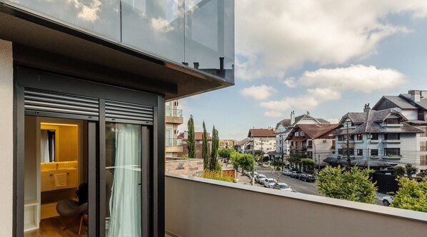 Un apartamento moderno con balcón que da a una calle y casas vecinas.
