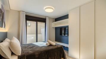 Un dormitorio con cama, ventana y luz de techo.