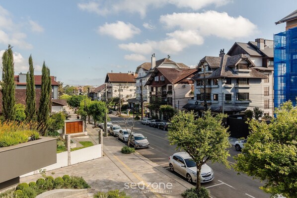 Una calle residencial con casas, coches aparcados y árboles.