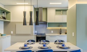 Una cocina moderna con comedor dispuesto para cuatro personas.