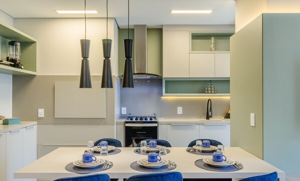 A modern kitchen with a dining area set for four. - Beautiful Apartment in Gramado Dlh0201 (Gramado)