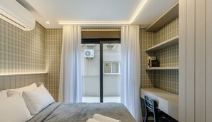 Quarto moderno com cama, escrivaninha e estante.