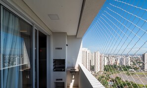 A balcony with a view of a cityscape, a window with curtains, and a small sink. - Strategic Apt, Jardim Goias - Tho2707 (Goiânia)