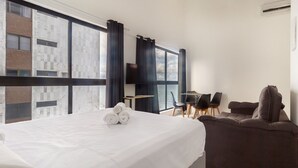 A hotel room with a bed, a desk, a chair, a sofa, and a TV. - Modern Beachside Comfort in Boa Viagem - Iaa1004 (Recife)