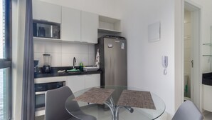 A modern kitchen with a glass dining table, stainless steel appliances, and a view of the outside. - Luxury Beachfront Apt in Boa Viagem - Iaa1003 (Recife)