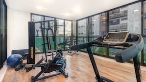 A gym with cardio equipment, weight machines, and a rowing machine. - Luxury Beachfront Apt in Boa Viagem - Iaa1003 (Recife)